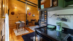 A cozy cabin interior with a wooden interior, a dining area, and a kitchenette.