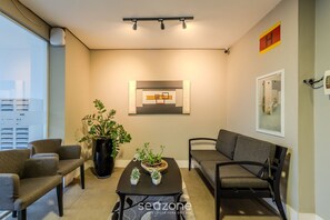 A modern living room with a sofa, chairs, a coffee table, and a potted plant. - Beautiful Apartment in Itajai Ctp1103 (Itajai)