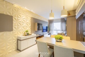 A modern kitchen with a dining area, featuring a geometric wall pattern, a central island, and pendant lighting. - Beautiful Apartment in Itajai Ctp1103 (Itajai)