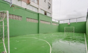 An indoor sports court with green flooring and white lines, a goalpost, and a net. - Beautiful Apartment in Itajai Ctp1103 (Itajai)