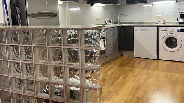 A modern kitchen with stainless steel appliances, a built-in oven, and a washing machine. - Bright Two-Bedroom Apartment in Maragall (Barcelona)