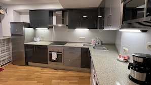 A modern kitchen with a built-in oven, a stainless steel refrigerator, and a coffee maker. - Bright Two-Bedroom Apartment in Maragall (Barcelona)