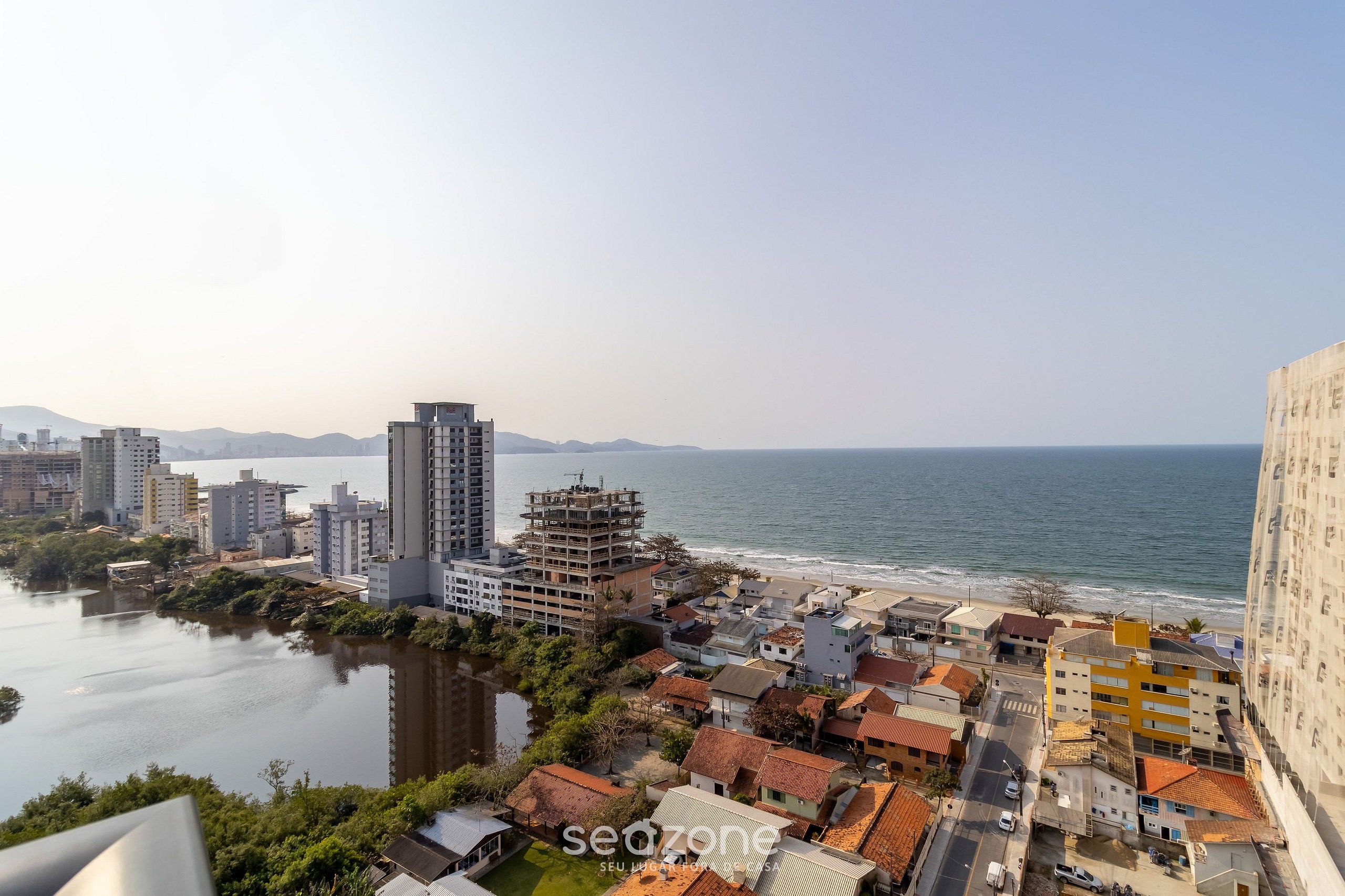 A coastal cityscape with a river, buildings, and a beach.