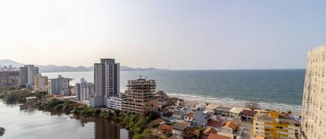 A coastal cityscape with a river, buildings, and a beach.