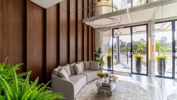 Een modern interieur met een gebogen bank, een ronde salontafel en een groot raam met uitzicht op de stad.