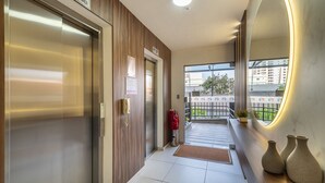 A hotel lobby with an elevator, a reception desk, and a view of the outside balcony. - 2BR Apt w/ Pool & BBQ 210m - Csi0302 (Picarras)