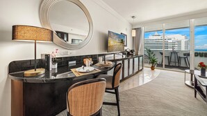 Habitación de hotel moderna con una encimera negra curva, un espejo grande y vistas a un crucero a través de ventanas de pared a techo.