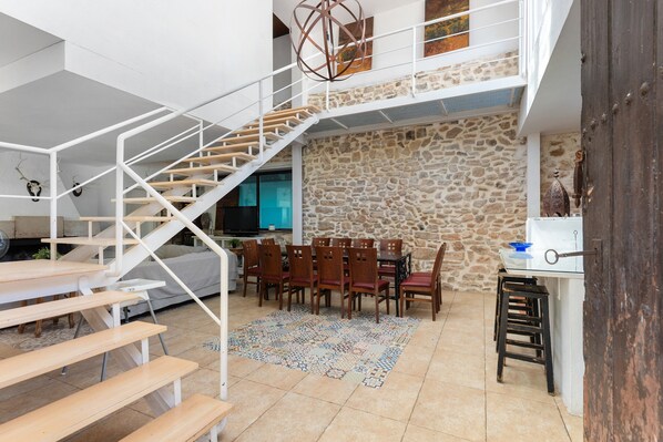 A spacious interior with a staircase, dining area, and kitchen.