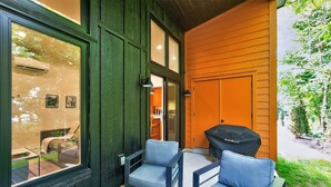 A patio area with two blue chairs, a grill, and a view of the backyard. - 500 House - Unit A 1 Bedroom Townhouse (Mequon)