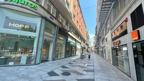 A street with various storefronts, including a visible shoe store and a clothing store.