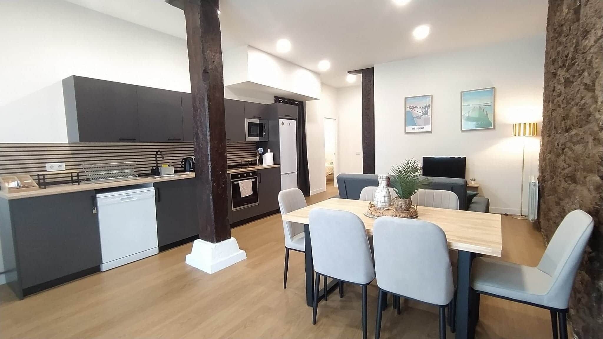 A compact living space with a kitchenette, dining area, and a seating area with a television.