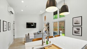 A modern kitchen with a central island, stainless steel appliances, and pendant lighting. - 500 House - Unit C 1 Bedroom Townhouse (Mequon)