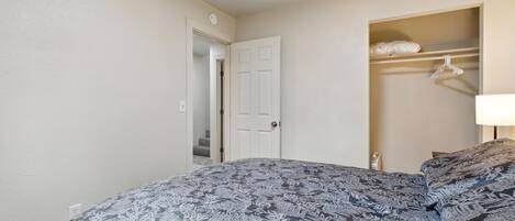 A bedroom with a bed, a closet, and a nightstand.