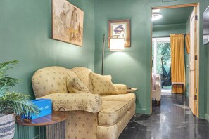 Un salon avec un canapé, une lampe et un tableau encadré au mur.