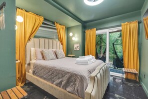 A bedroom with a large bed, a small table, and a hammock.