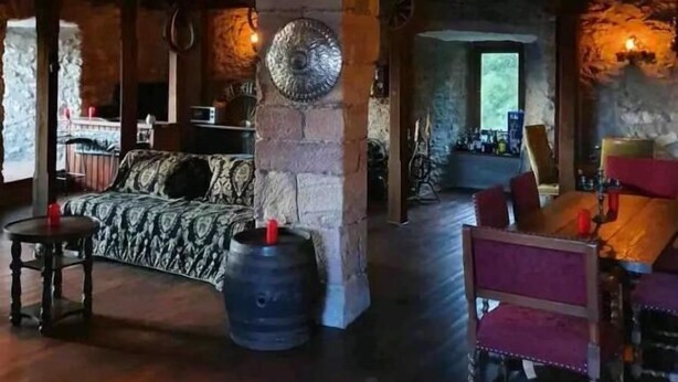 A rustic interior with stone pillars, wooden furniture, and a balcony. - Burg Hermannstein - Rittersaal  (Wetzlar)