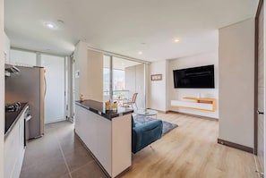 A modern apartment with a kitchen, dining area, and living room.