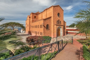 A large building with a prominent clock tower, arched windows, and a central doorway.