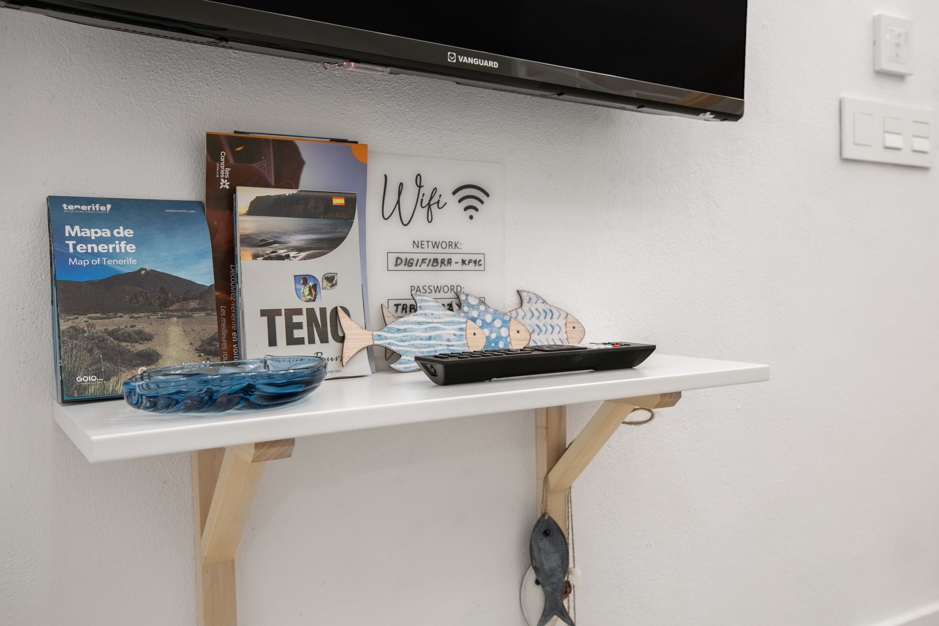 Una estant amb un mapa, un router, un teclat i una decoració de peix.