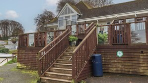 A wooden staircase leading to a building with a balcony. - I C Lundy Too (Bideford)