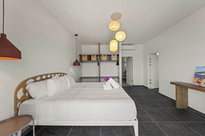 A modern bedroom with a bed, bedside table, and a painting on the wall.