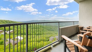 Ein Balkon mit Blick auf eine grüne Landschaft und ferne Berge.