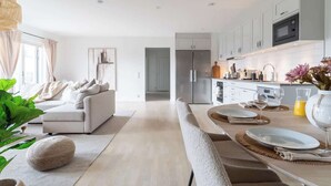 A modern kitchen with white cabinets, a built-in oven, and a stainless steel refrigerator. - Fully Equipped Home in Bastad with Cozy Patio (Båstad)