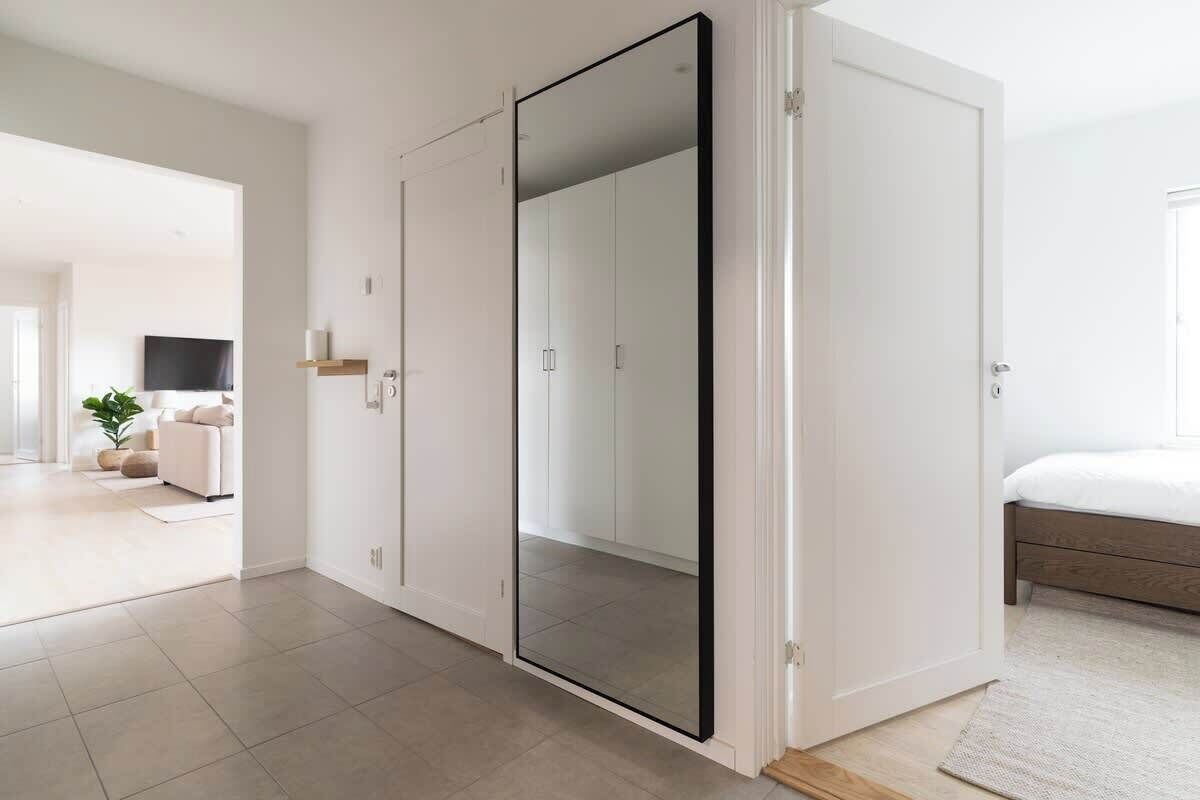 Een moderne slaapkamer met een grote kledingkast, een bed en een televisie op de achtergrond.