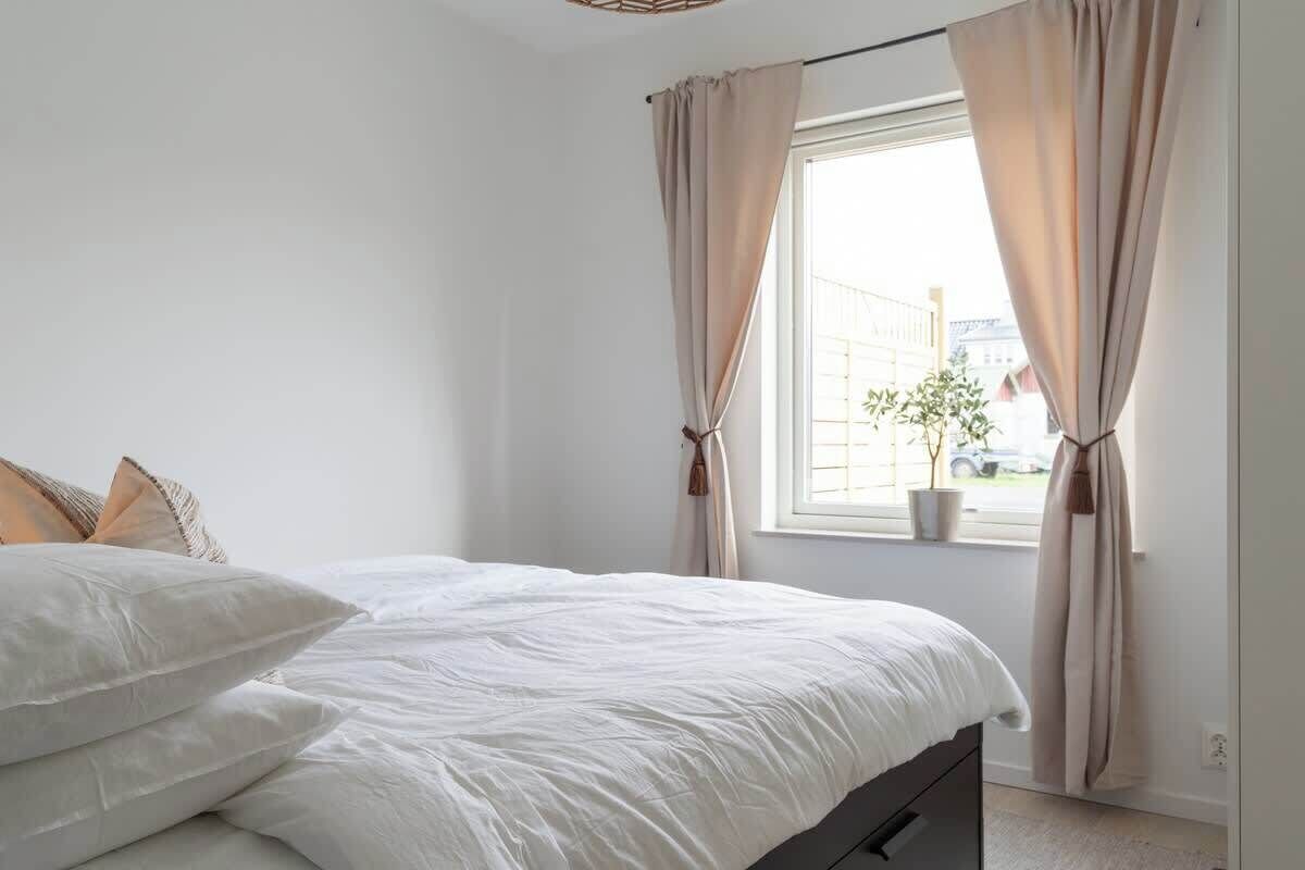 Una camera da letto con un letto, tende e una finestra vista strada.