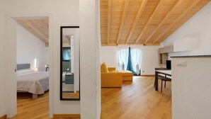 Una habitació amb un llit, un sofà, una taula de dinar i un mirall.