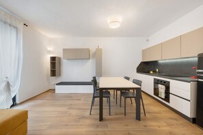 Una cocina moderna con una mesa de comedor, sillas y electrodomésticos integrados.