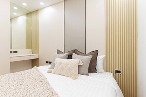 Ein modernes Schlafzimmer mit Bett, Nachttisch und Spiegel.