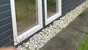 Una casa con amplios ventanales, un camino de piedra y un pequeño césped.