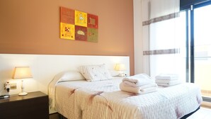 A hotel room with a large bed, two bedside lamps, a nightstand, and a wall art piece.