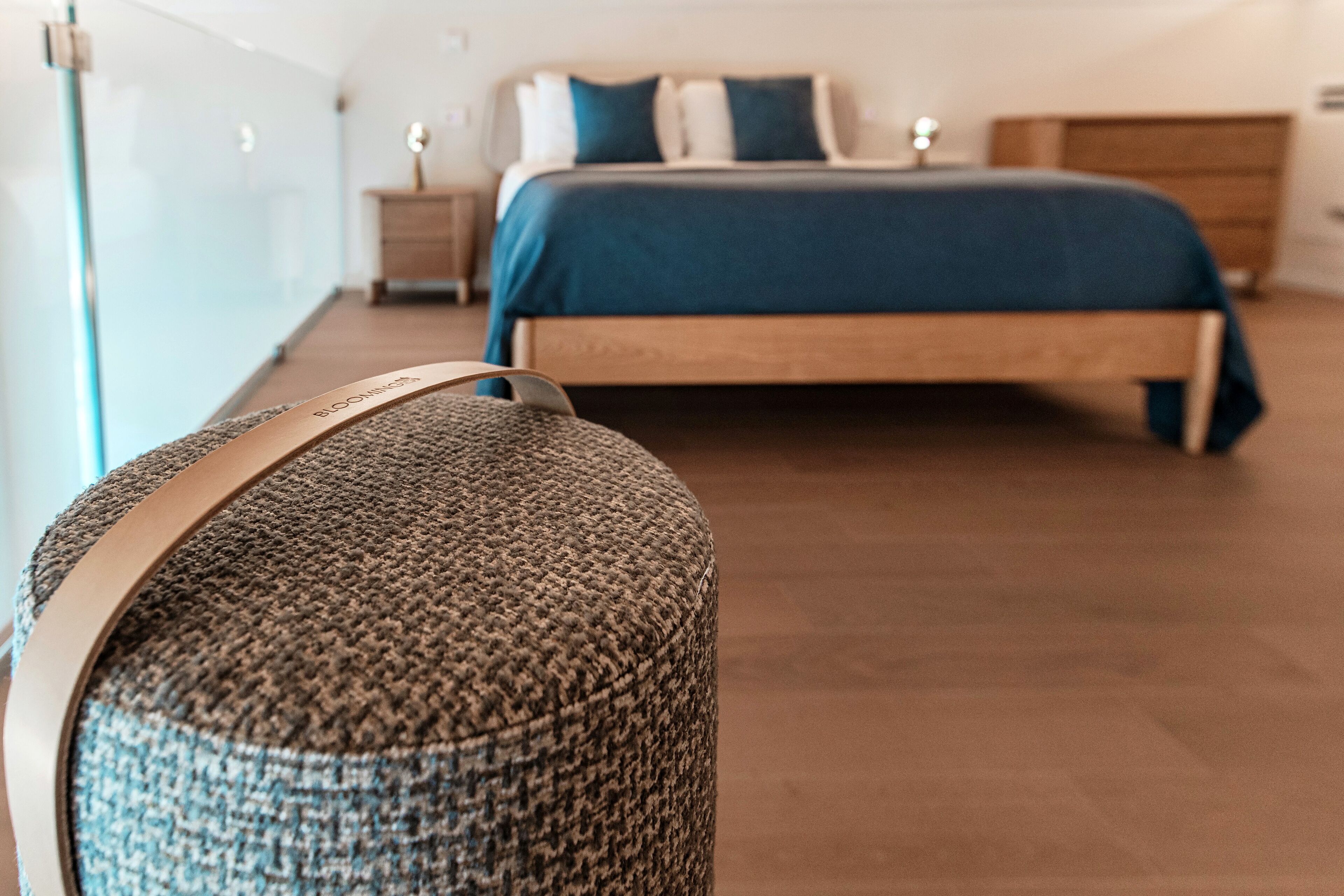 A bedroom with a bed, a nightstand, and a wooden dresser.