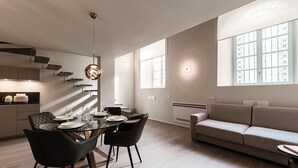 Una cocina moderna con comedor, sofá y un amplio ventanal.