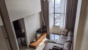 A modern living room with a sofa, a coffee table, and a TV.