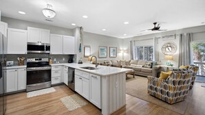 A modern kitchen with white cabinets, stainless steel appliances, and a central island.