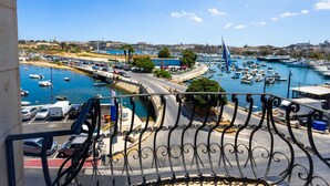 A marina with boats, a clear blue sky, and a view of the city in the background. - Cosy Apartment with Valletta and Harbour Views (Sliema)
