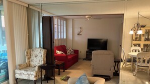 Un salon avec un canapé, un fauteuil et un téléviseur.