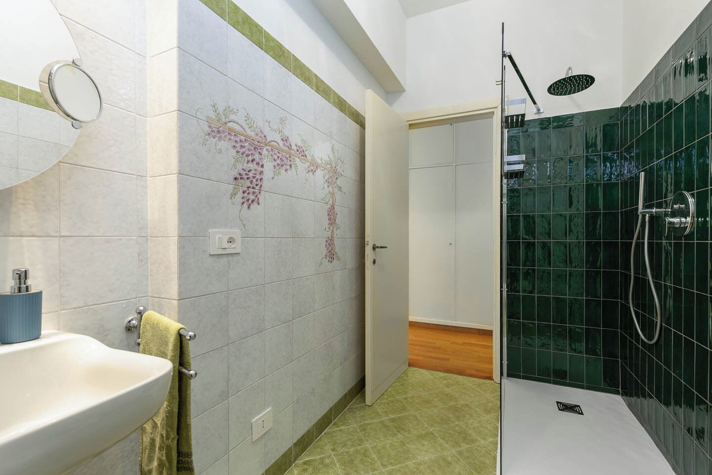 A bathroom with a sink, mirror, and shower area.