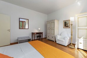 A bedroom with a bed, a desk, a chair, a wardrobe, and a lamp. - Elegant apartment in the setting of Siena with air conditioning, WI-FI and TV (Siena)