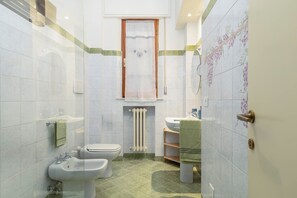 A bathroom with a toilet, bidet, sink, and shower. - Elegant apartment in the setting of Siena with air conditioning, WI-FI and TV (Siena)