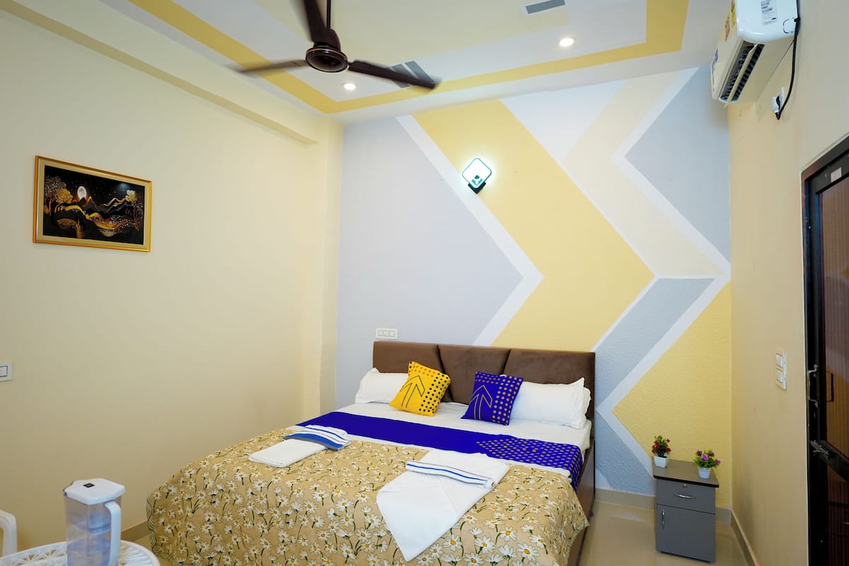 A neatly arranged bedroom with a bed, bedside table, and a ceiling fan.