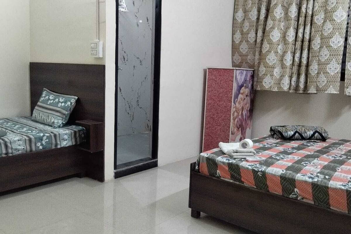 A bedroom with two beds, a wardrobe, and a mirror.