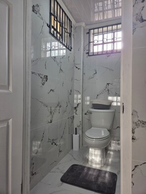 Een douche, handdoeken, zeep, toiletpapier