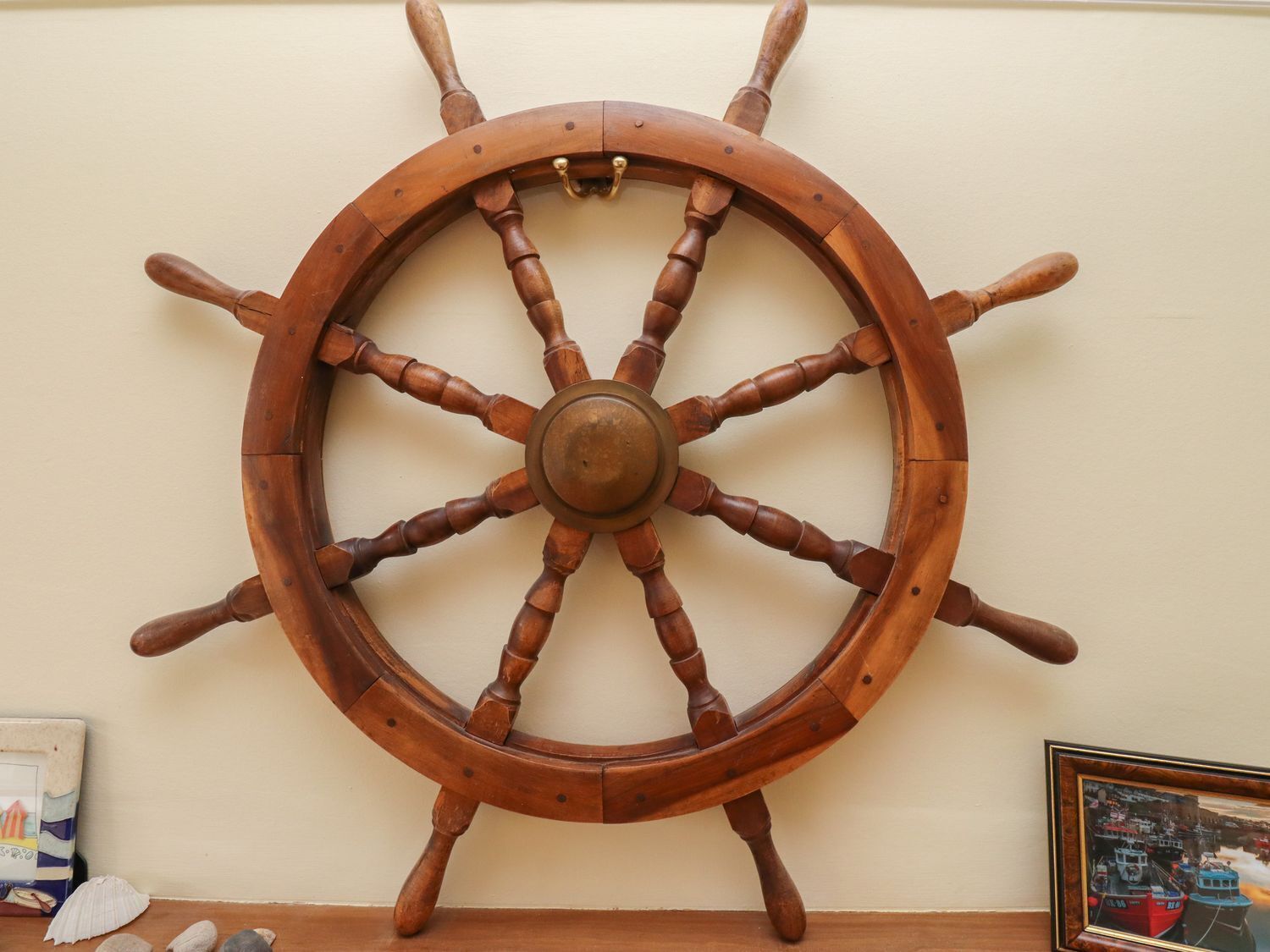 A wooden ship's wheel mounted on a wall.