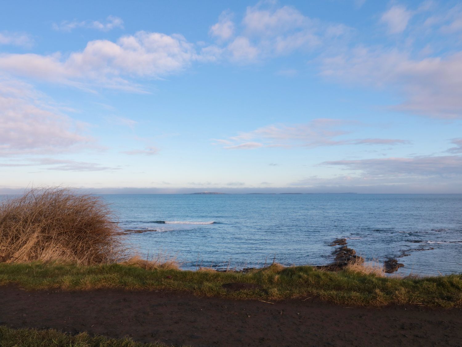 A coastal landscape with a clear sky and calm sea.
