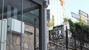 A building with a stone facade, a metal staircase, and a glass entrance. - Refletion of the Bosphorus (İstanbul)