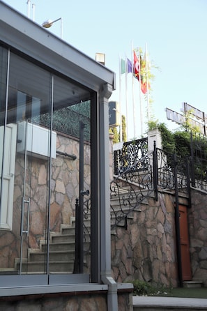 A building with a stone facade, a metal staircase, and a glass entrance. - Refletion of the Bosphorus (İstanbul)